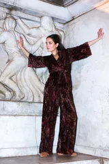 Pantalón de corte recto y holgado confeccionado en terciopelo estampado con diseño de motivos circulares en tonos bordó y negro.