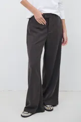 Pantalon de corte sastrero y pierna ancha, confeccionado en tela melange. Presenta cintura con trabillas, cierre frontal con botón y bolsillos laterales.
