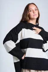Sweater de punto con rayas horizontales anchas en blanco y negro. De corte amplio y relajado, brinda máxima comodidad sin perder el estilo. Su diseño atemporal lo convierte en una prenda versátil, ideal para combinar con jeans o pantalones para un look casual y abrigado en los días más frescos.