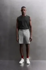 Pantalones cortos de algodón color gris, con cintura elástica ajustable con cordón y parche con logo. Incluye bolsillos laterales y un bolsillo trasero. Presenta bandas laterales a tono, bordado y estampado combinado a contraste en el delantero y la espalda, y aberturas laterales en el bajo.