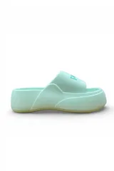 Chancletas blancas de plataforma con faja ancha y suela de goma. Tienen detalles en color salmón en la faja y suela tostada.