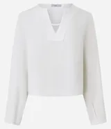 Blusa blanca de crepé con cuello en V, mangas largas y pliegues en los puños.