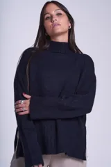 Sweater color crema de media polera, corte holgado y mangas largas. Tejido de punto con detalles acanalados en cuello, puños y ruedo.