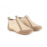 Zapato bajo de cuero color beige con refuerzos en gamuza en la puntera y el talón. Cuenta con doble cierre lateral diagonal, presilla trasera y suela de goma con relieve.
