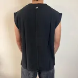 Musculosa de tejido de punto en color negro, con corte oversize y terminaciones desflecadas en las sisas.