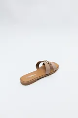 Sandalias planas de diseño abierto, color tostado, con capellada de tiras anchas y un herraje metálico circular en el centro.