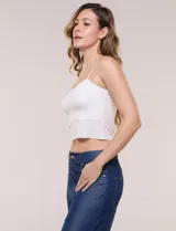 Top crop de punto elastizado color beige, con escote recto y tirantes finos regulables. Presenta una trama texturada con franjas horizontales.