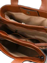 Cartera shopper de cuero graneado metalizado en color plateado, con asas y detalle de borla colgante en color tostado. Cuenta con dos compartimentos con cierre y uno con broche magnético.