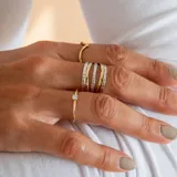 Anillo de diseño multicapa elaborado en oro de 10k, combinando bandas en oro amarillo y oro blanco con acabado facetado.