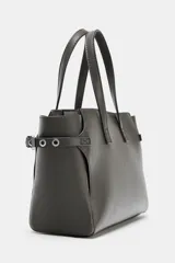 Bolso mini shopper de color gris oscuro, con diseño estructurado, doble asa de mano y correas laterales decorativas con hebillas metálicas. Incluye cierre magnético y compartimento interior con cremallera.
