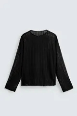 Jersey de punto negro, corte relajado, con cuello redondo y manga larga. Presenta una textura abierta o desagujada con rayas verticales y acabados irregulares.