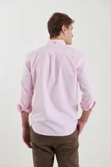 Camisa de vestir blanca de manga larga, con cuello abotonado, bolsillo frontal y botones en tono madera.