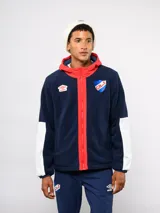 Campera de polar blanca con capucha y detalles en azul marino, con cierre frontal completo. Presenta el logo de Umbro y el escudo del Club Nacional de Football en el pecho.
