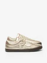 Championes Veja modelo Panenka en color dorado metalizado, con logo lateral en tono crema y suela de goma oscura. Presenta detalles en color rosa en la lengüeta y el talón.