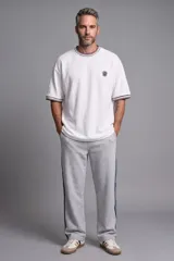 Pantalón deportivo gris melange con tiras laterales oscuras y corte recto.