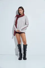 Sweater gris de calce relajado con cuello redondo y mangas largas. Presenta detalles de rayas horizontales en color rojo a lo largo de las mangas, con puños y ruedo acanalados.