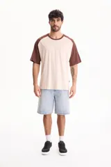 Remera oversize de manga corta raglán, color blanco con mangas y cuello en azul marino.