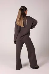 Conjunto de dos piezas compuesto por un sweater de cuello alto y pantalón de corte recto, ambos confeccionados en tejido de punto acanalado.