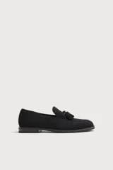Mocasines de vestir para hombre confeccionados en piel con acabado en serraje de color azul marino, con detalle de borlas en el empeine y suela con ligero tacón.