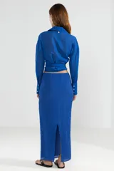 Camisa azul de manga larga con lazo en la cintura y botones nacarados.