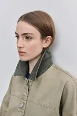 Campera de gabardina tostada, con cuello camisero de pana marrón, cierre frontal de botones metálicos y bolsillos delanteros aplicados con solapa.