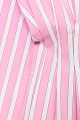 Camisa de popelina con diseño a rayas verticales rosadas y blancas, cuello solapa con escote en V, manga larga y detalle de pliegues marcados en la cintura. Cierre frontal con botones ocultos.