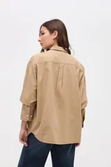 Sobrecamisa de algodón color marrón, con cuello solapa, cierre frontal de botones y bolsillos frontales en el pecho.