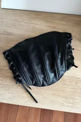 Top corset negro de cuero ovino con cordones laterales.