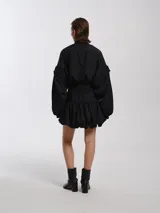 Campera negra estilo bomber con cuello alto, faja de puño ancha, mangas desmontables y forro de felpa.