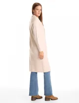 Chaqueta larga de tejido de punto color beige, con cuello de solapa, cierre frontal de un solo botón y mangas largas.