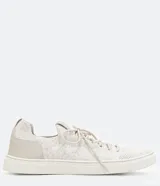 Zapatillas deportivas de punto color gris claro, con cierre de cordones y suela blanca.