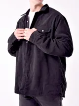 Sobrecamisa de hombre color azul marino, confeccionada en tejido de pana con textura acanalada. Presenta cuello camisero, cierre frontal con botones blancos y dos bolsillos de parche con solapa en el pecho.