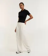 Blusa polo de manga corta color marrón, confeccionada en tejido canelado de rib de algodón con elastano. Presenta cuello estructurado y un ajuste ceñido al cuerpo.