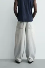 Jeans de mezclilla, tiro medio, color celeste claro lavado con efecto desgastado y roturas pronunciadas en ambas piernas. Corte ancho y relajado.