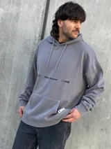 Canguro gris con capucha ajustable con cordones, bolsillo tipo canguro y logo estampado en el pecho.