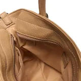 Cartera chica color camel, confeccionada en símil cuero con textura granulada. Cuenta con asas de mano fijas, correa larga de tela ajustable y desmontable, y detalles de cordones ajustables en los laterales. Incluye herrajes metálicos plateados y logo de la marca en la parte frontal.