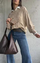 Sweater de punto color beige con diseño bordado en relieve de flores y hojas. Presenta cuello redondo, mangas largas con puños acanalados y un corte holgado.