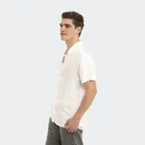 Camisa de manga corta color blanco, con cuello clásico y cierre frontal de botones.