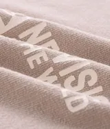 Remera de manga larga marca Blue Steel, color beige, con cuello redondo y corte holgado. Presenta estampado frontal con el texto 'New Vision of the World' y gráficos decorativos en una de las mangas.