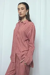 Camisa de viscosa con estampado de rayas verticales en tonos rosado y marrón, de corte oversize, con cuello camisero, cierre frontal de botones y mangas largas acampanadas.