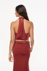 Top halter color bordó con escote profundo y tirantes decorados con cuentas artesanales.