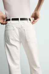 Jeans flare fit de tiro medio, confeccionados en denim de algodón color azul con efecto deslavado. Diseño ajustado en la parte superior y abierto en campana desde la rodilla, con cinco bolsillos y cierre frontal con cremallera y botón.