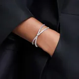 Brazalete rígido abierto con baño de rodio y cristales Swarovski Zirconia transparentes engastados.