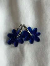 Aros de argolla metálica con dije colgante en forma de flor de acrílico color rosado.