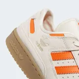 Zapatillas Adidas Forum Low CL color crema con detalles en naranja y suela marrón.
