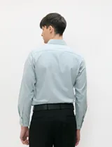 Camisa de manga larga de tejido Oxford color celeste, con cuello button-down, cierre frontal de botones y un bolsillo aplicado en el pecho.
