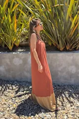 Vestido largo color ladrillo, de breteles finos y corte holgado. Presenta un panel inferior color beige.