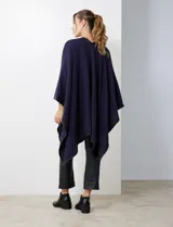 Ruana negra de tejido suave, con cierre frontal de botones metálicos y ribetes de cuero sintético en los bordes.