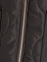 Campera acolchada de color gris oscuro, con diseño matelaseado de ondas, cuello alto en rib, cierre frontal con cremallera metálica y bolsillos frontales aplicados.