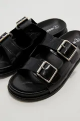 Sandalias planas de mujer con doble tira ancha en el empeine, hebillas metálicas plateadas y textura símil cocodrilo.
